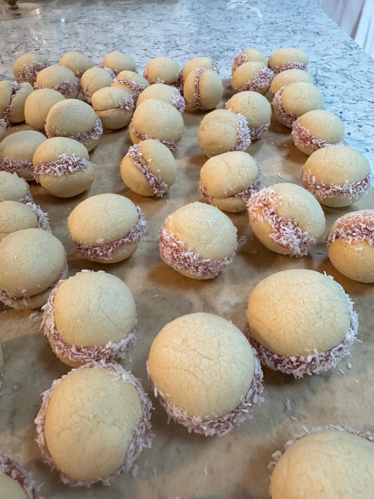 Coconut sandwich cookies on a marble counter